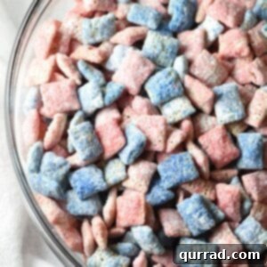 Red, White, and Blue Muddy Buddies - A quick and easy 15-minute Chex Mix recipe with a holiday flair for the 4th of July, featuring a bowl of the delicious and addictive snack.