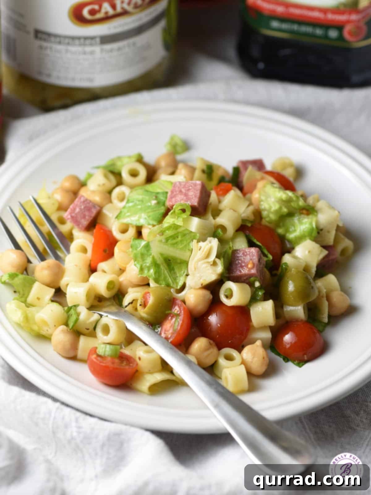Italian Deli Chopped Salad 4 A single serving of the vibrant Italian Chopped Salad presented on a white plate with a fork, ready to be enjoyed.