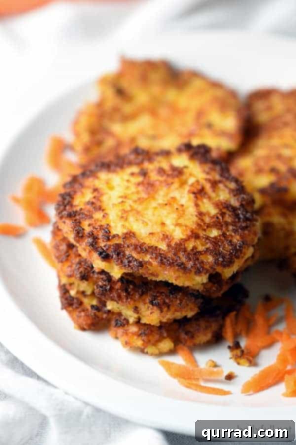 Perfectly Stacked Potato Carrot Latkes A close-up shot of a stack of freshly fried Potato Carrot Latkes, showing their crispy edges and golden hue, ready to be served.