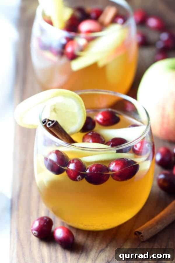 Festive Cranberry Apple Sangria with sliced apples and cranberries in a pitcher