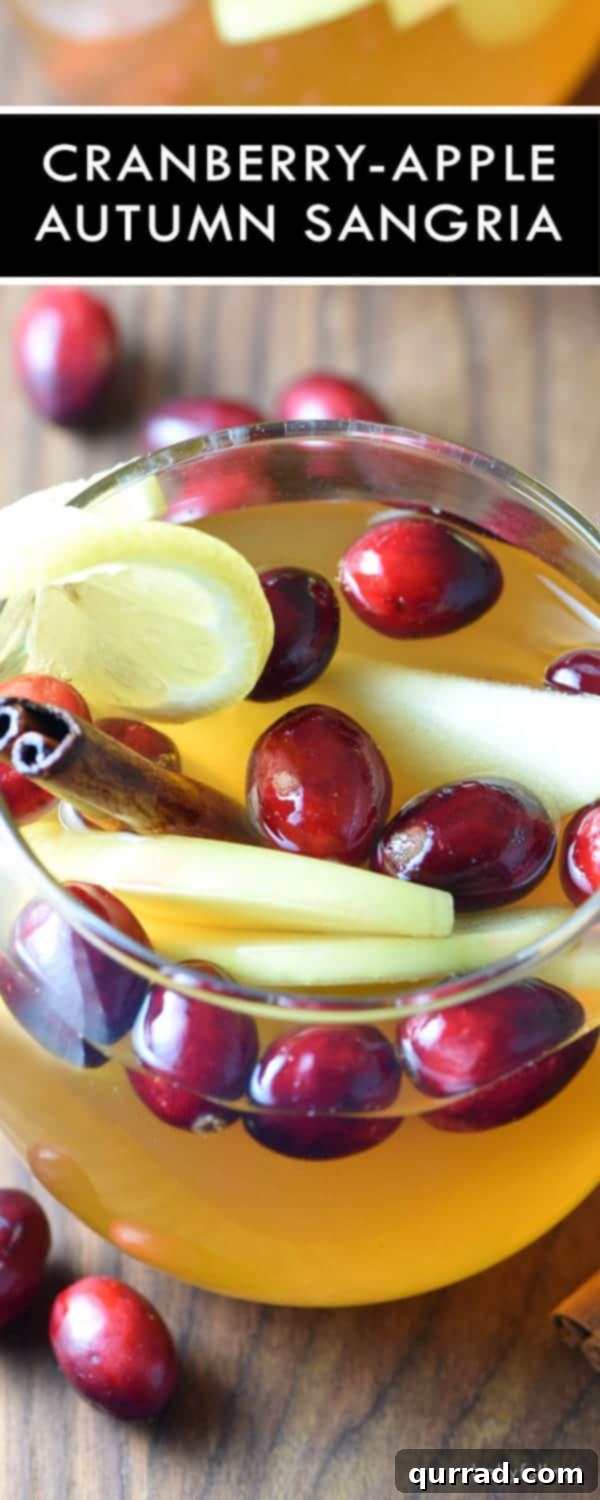 Pitcher of Cranberry Apple Fall Sangria with a festive backdrop