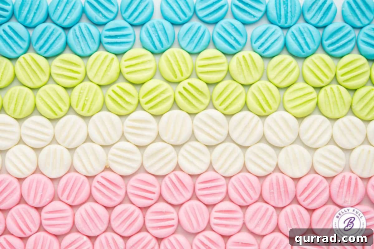 Velvety Mint Treats 3 Eight neat rows of colorful cream cheese mints in shades of pink, blue, green, and white, arranged meticulously on a surface.