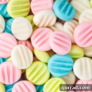 Close up image of pastel-colored cream cheese button mints, arranged to show their delicate texture and vibrant hues.