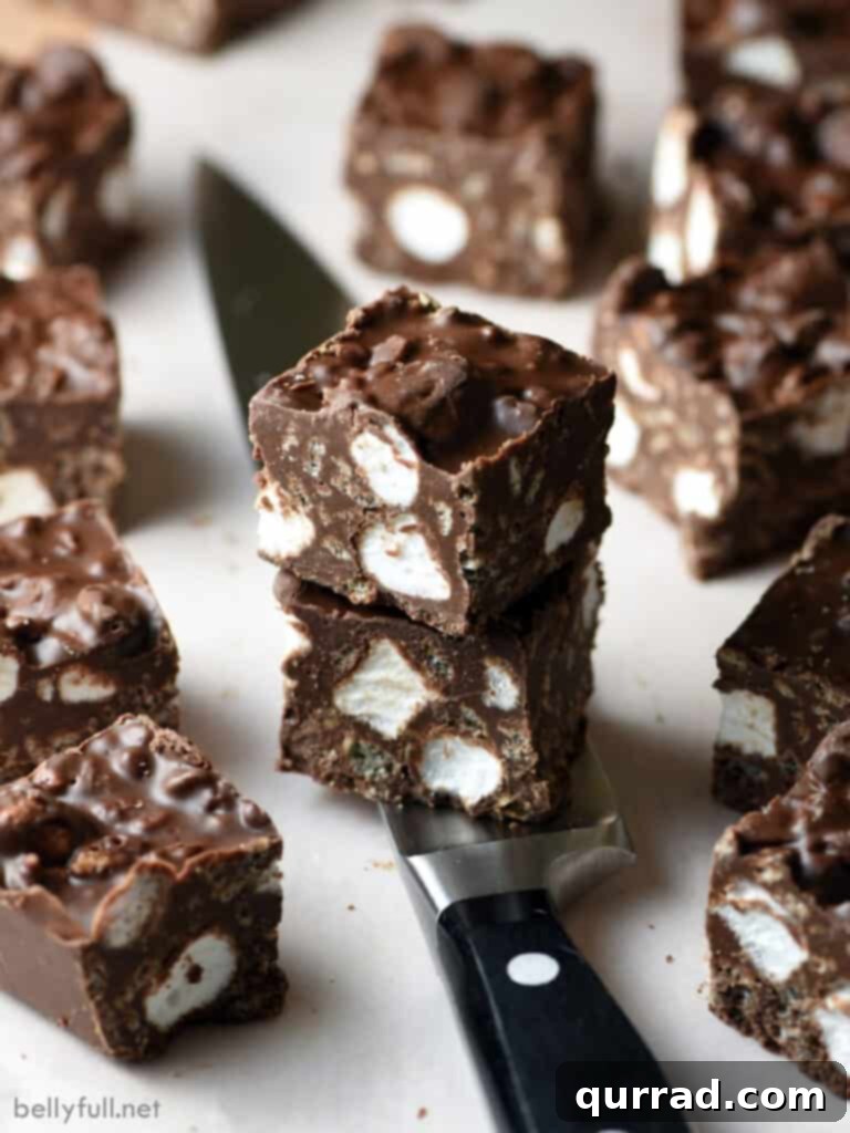 Loaded No-Bake Rocky Road Bars 3 close-up shot of avalanche bars stacked on a knife, showing the dense texture and ingredients