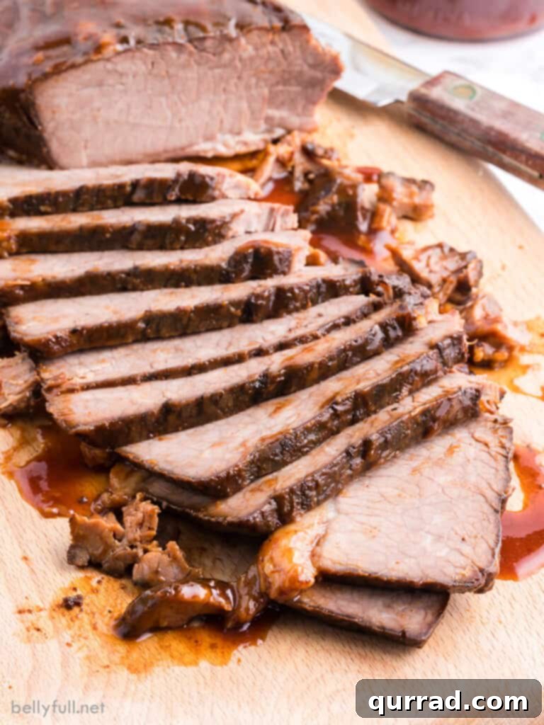 Perfectly sliced slow cooker beef brisket on a rustic cutting board, showcasing its tender texture and rich, barbecue glaze.