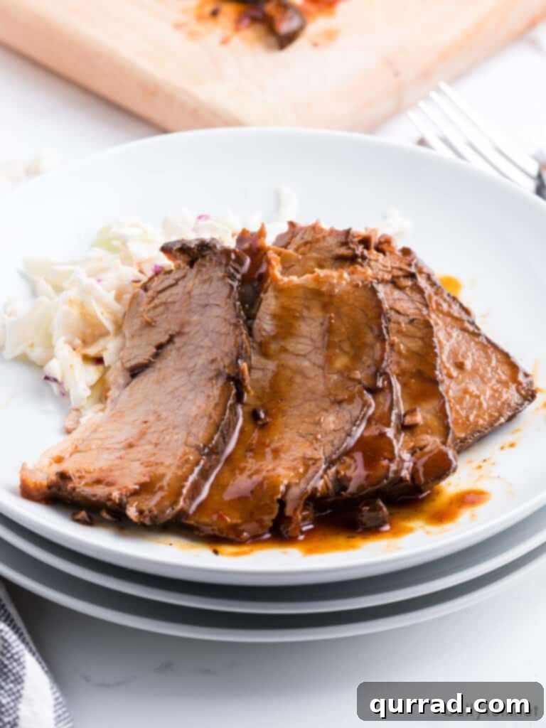 Five succulent slices of slow-cooked barbecue beef brisket, glistening with rich sauce on a pristine white plate, ready to be enjoyed.