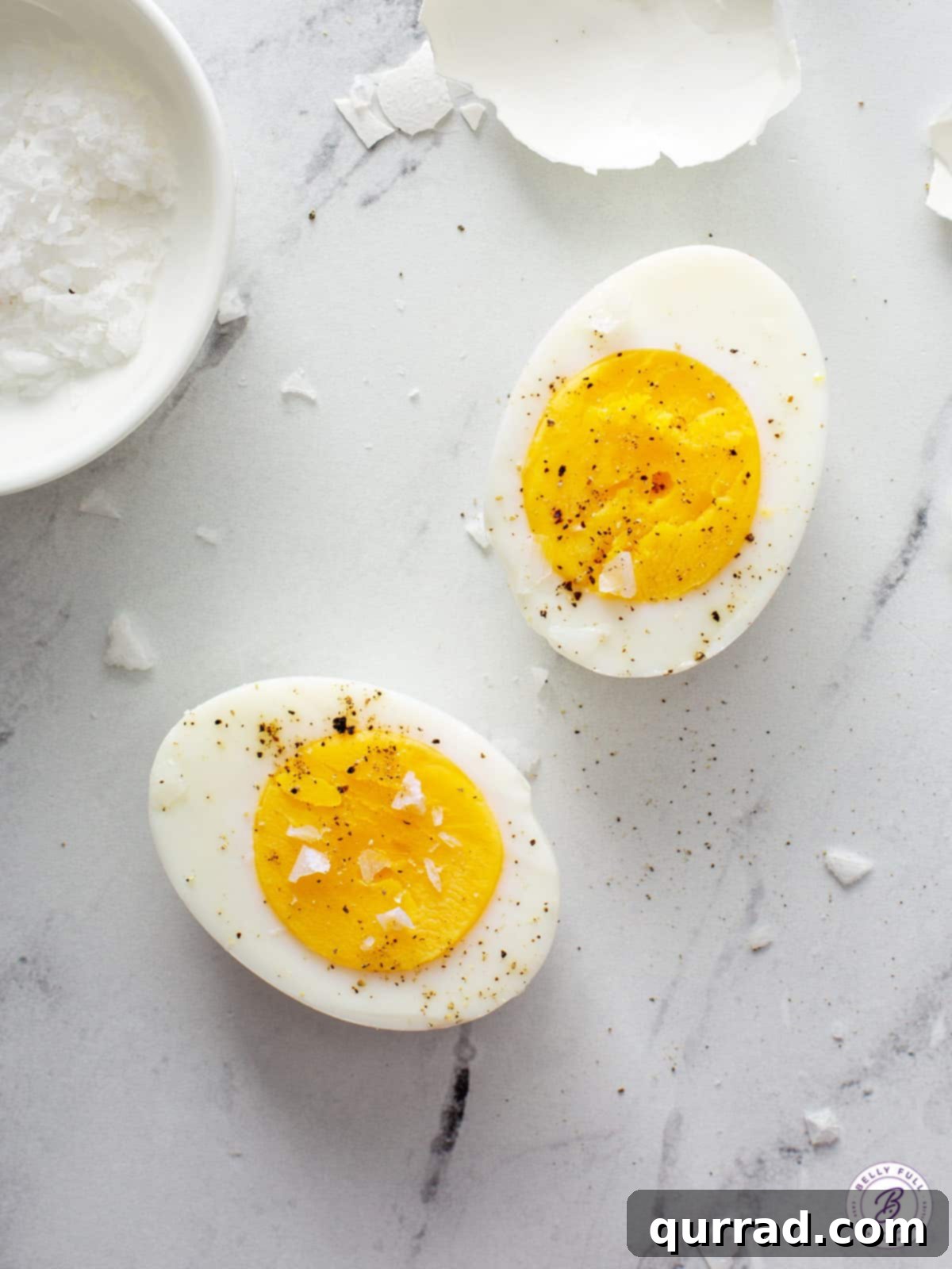 overhead hard boiled egg cut in half sprinkled with salt and pepper
