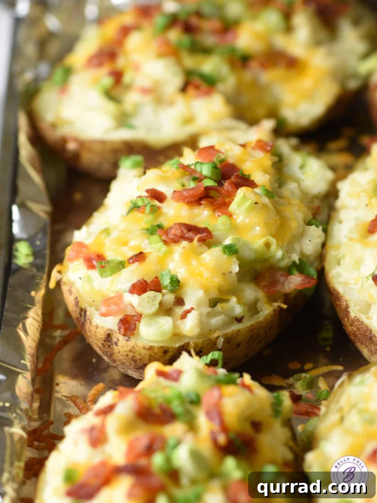 Baked potatoes generously topped with melted cheese, crumbled bacon, and fresh scallions