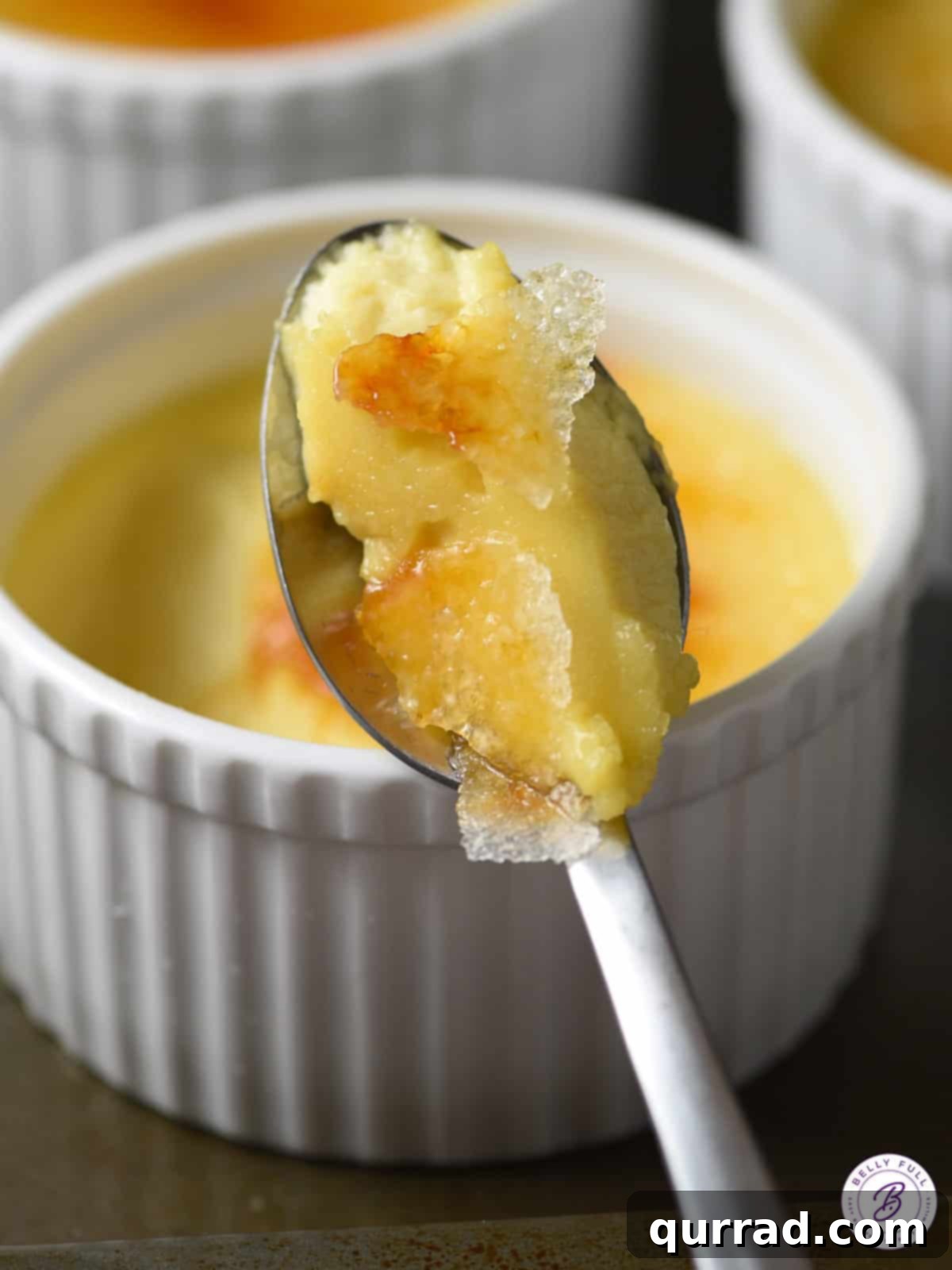 Slow Cooked Creme Brulee Dream 3 A spoonful of Slow Cooker Creme Brulee being lifted, showing the creamy custard and shattered caramel crust