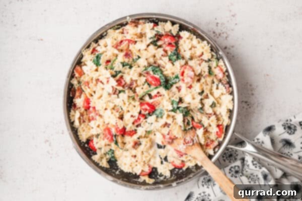 BLT Pasta being mixed in a skillet, with a perfect creamy sauce consistency