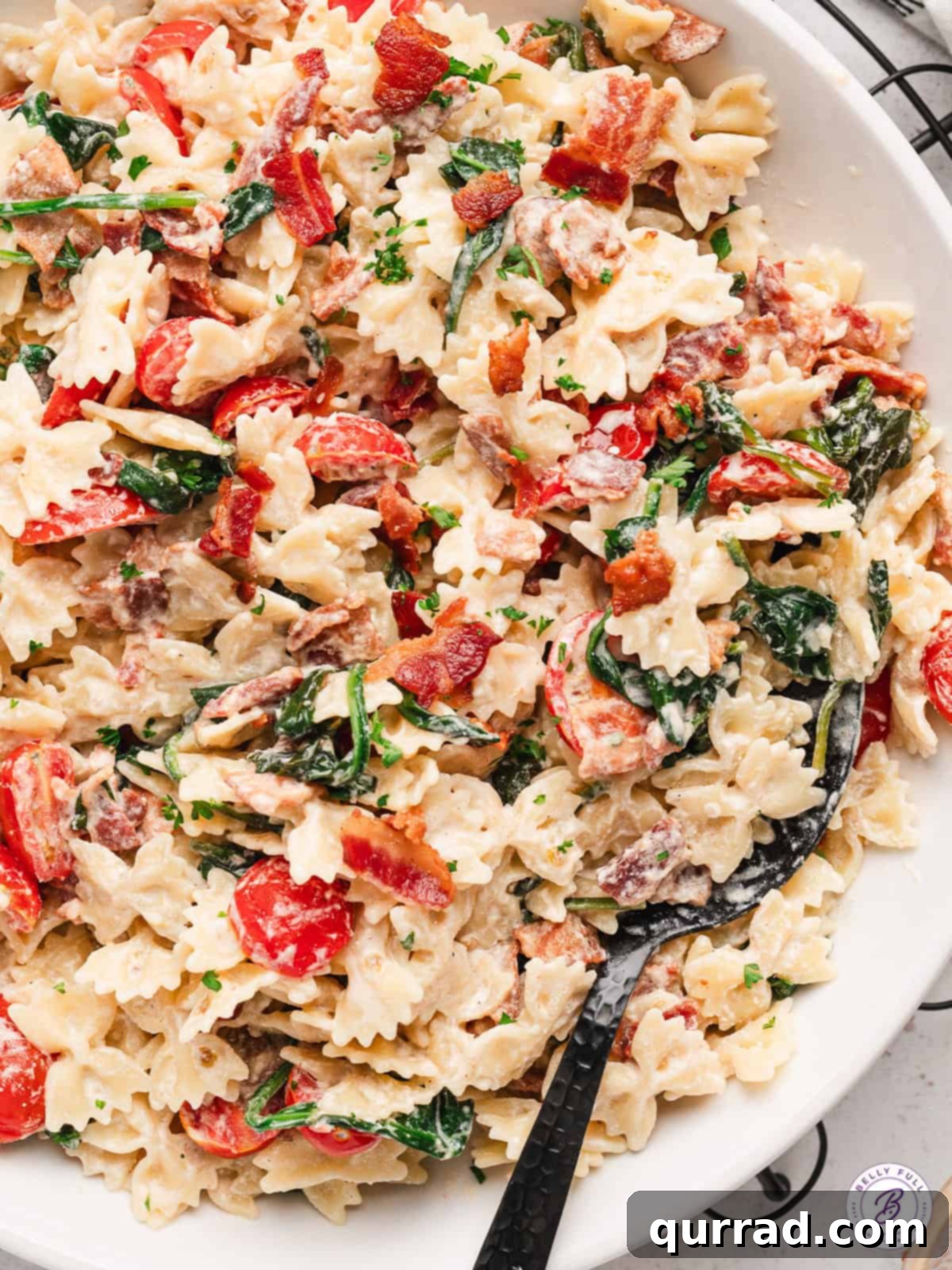 Ultimate BLT Pasta 13 A close-up shot of BLT Pasta in a bowl, showing the texture of the creamy sauce, pasta, bacon, and tomatoes.