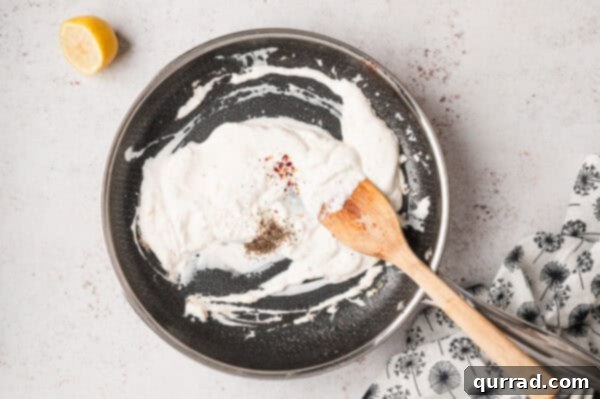 Crème fraîche mixed with spices and lemon juice in a pan