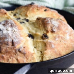baked loaf of bread in cast iron skillet