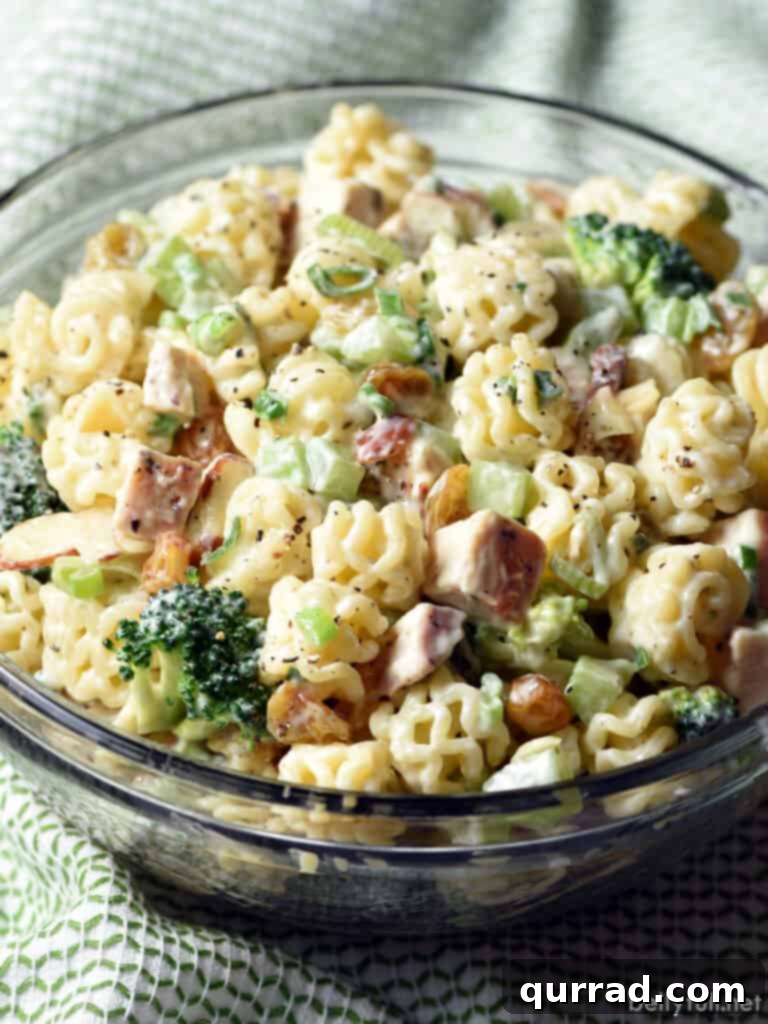 Hearty Chicken and Broccoli Pasta Salad 3 Close-up shot of creamy Chicken Broccoli Pasta Salad in a white serving bowl, highlighting the texture of the dressing and the chopped ingredients.