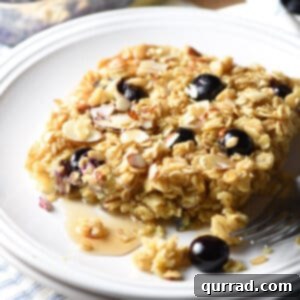 oatmeal square on plate with blueberries and maple syrup
