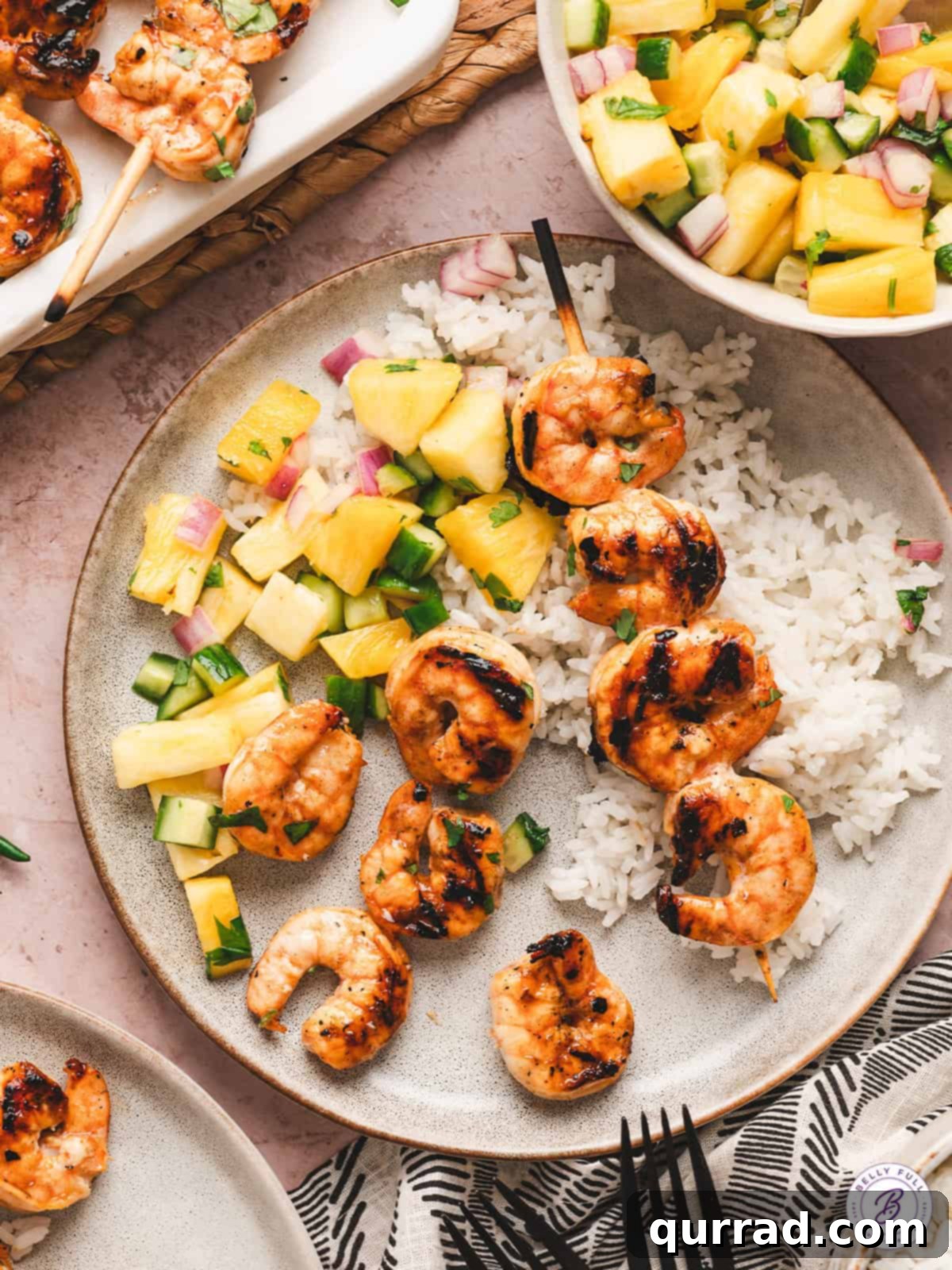 Zesty Thai Grilled Shrimp 11 A beautifully composed plate of Thai grilled shrimp, accompanied by fragrant coconut rice and a refreshing pineapple cucumber salad, highlighting a complete meal.