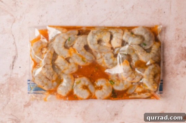 Raw shrimp fully coated in the Thai marinade inside a sealed plastic bag.