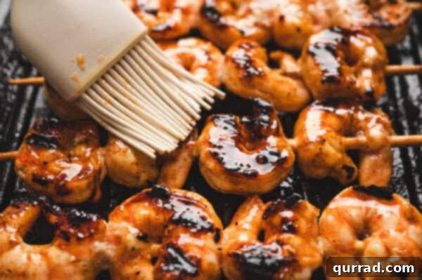 Grilled shrimp skewers being basted with the flavorful marinade directly on the hot grill.
