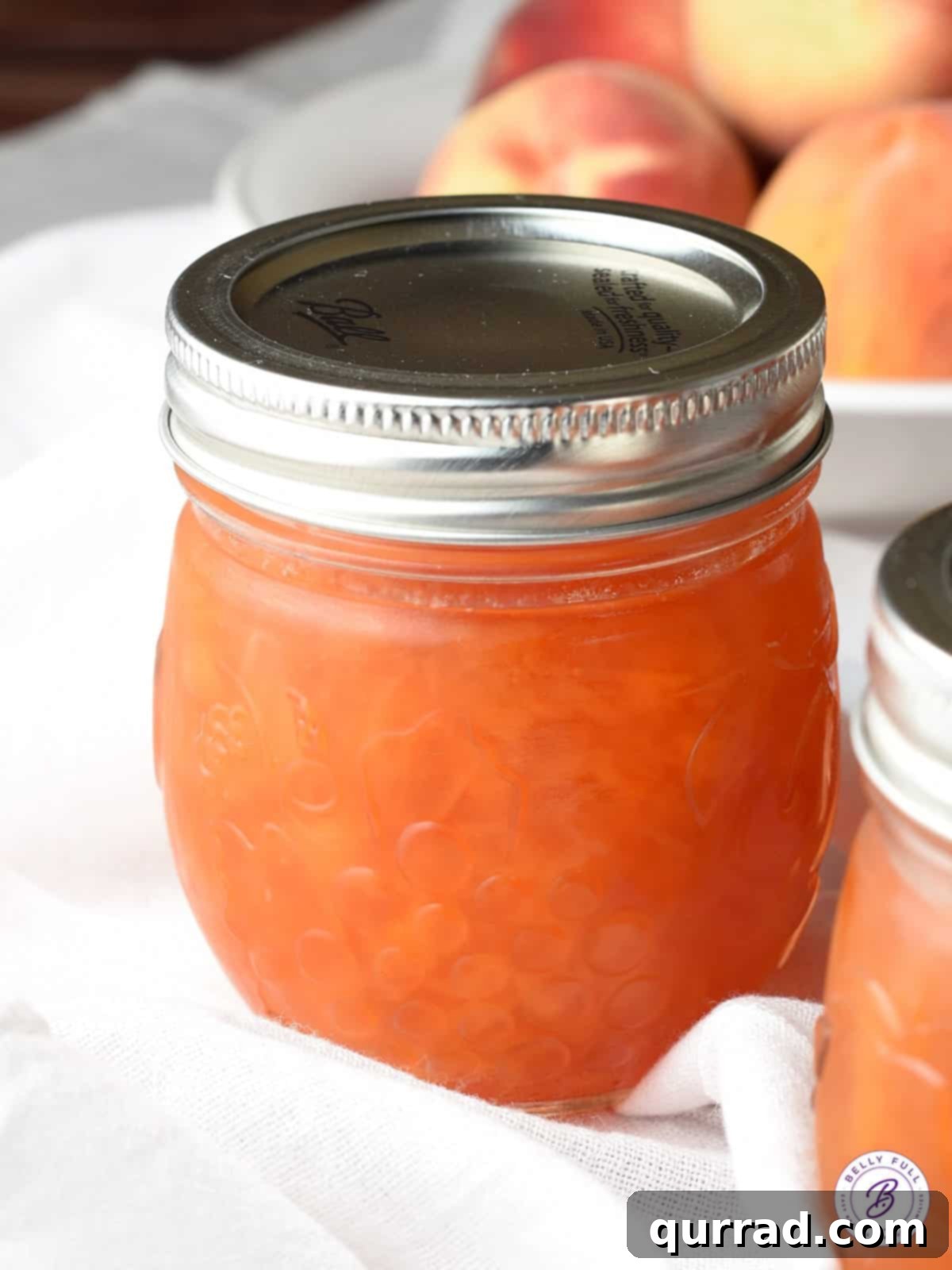 Golden Summer Peach Preserve 7 A single canning jar, neatly filled with homemade peach jam and sealed with its lid, ready for cooling.