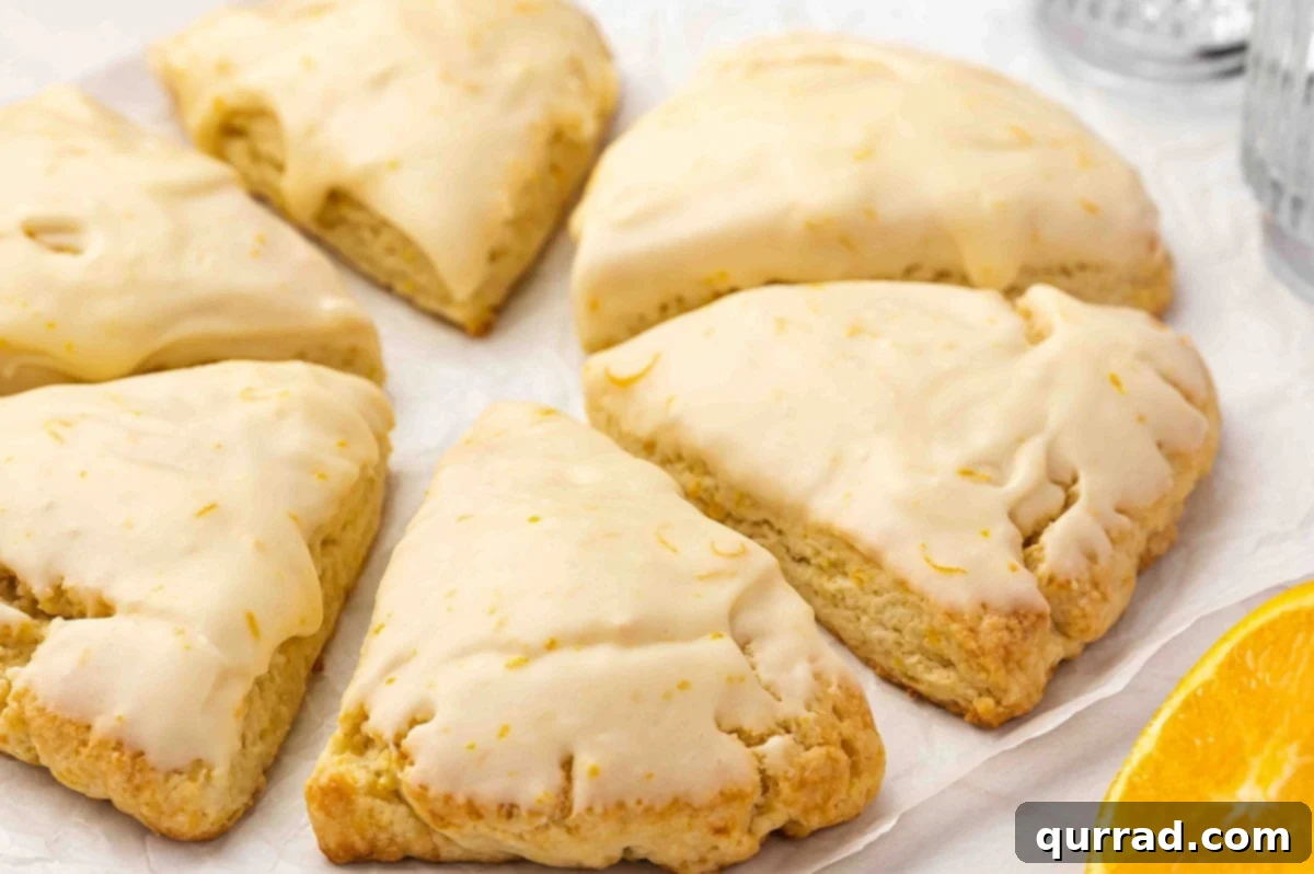 Beautifully Glazed Orange Creamsicle Scones Freshly glazed orange creamsicle scones artfully arranged on a clean white plate