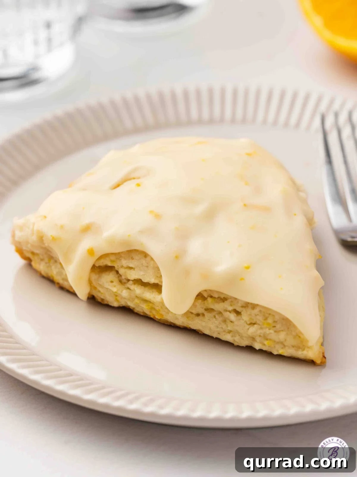 A Single Perfect Orange Creamsicle Scone A single, perfectly glazed orange creamsicle scone resting on a white plate