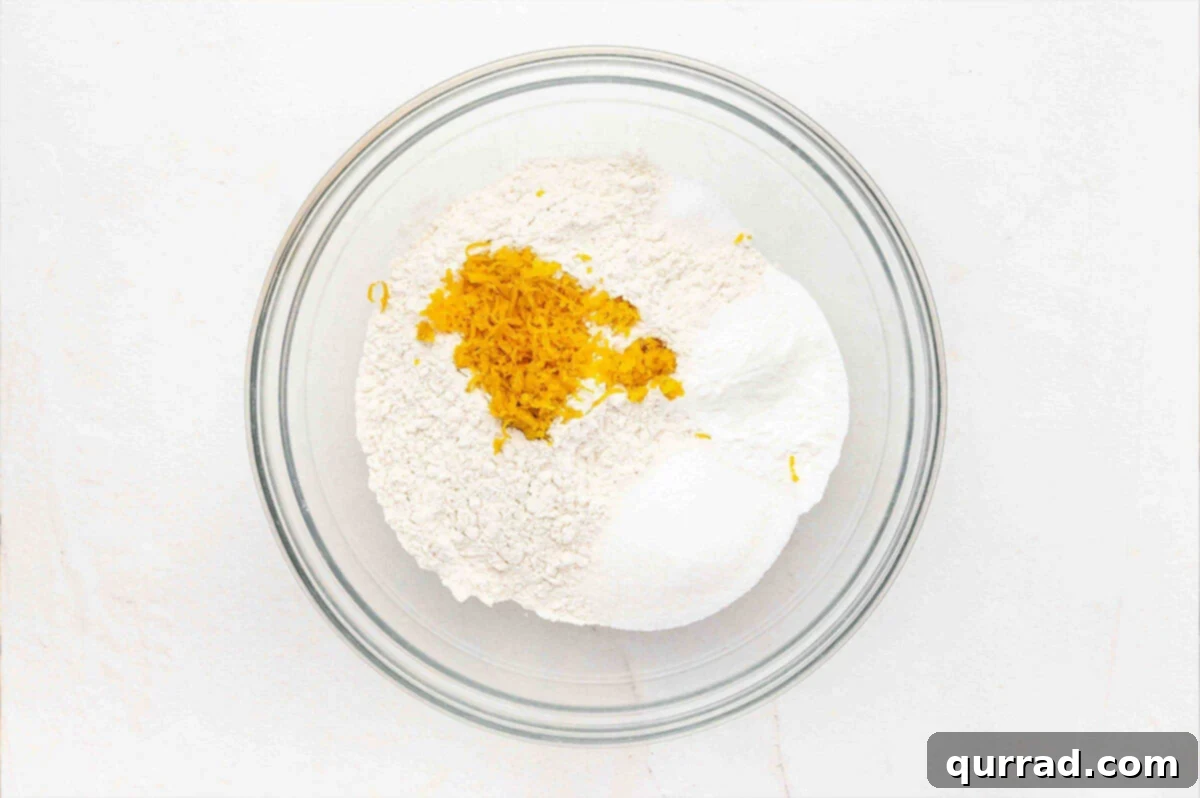 Combine Dry Ingredients and Orange Zest for Scones Dry ingredients and fresh orange zest neatly combined in a mixing bowl