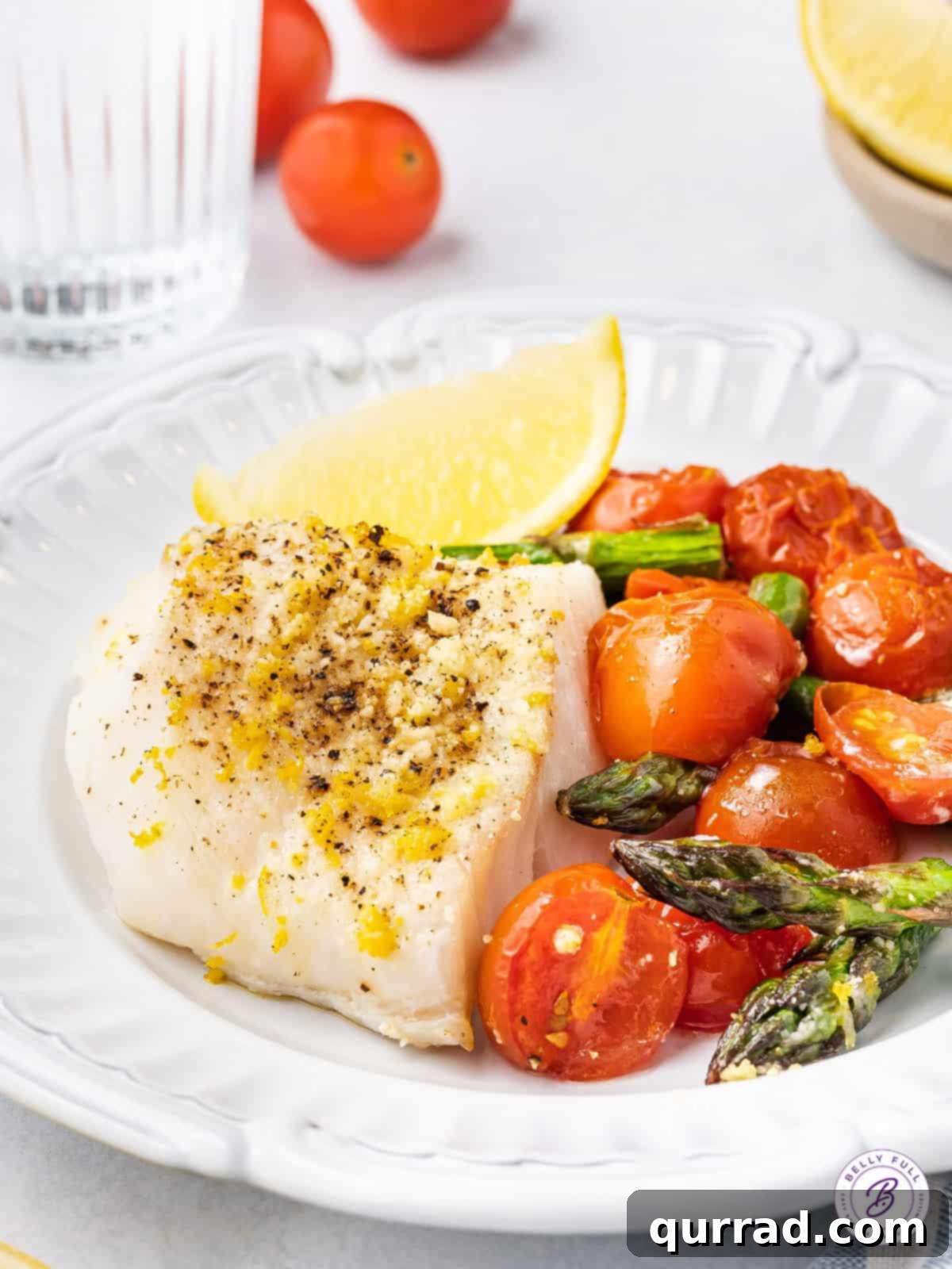 One Pan Wonder Baked Cod 5 baked cod on plate with roasted tomatoes and asparagus
