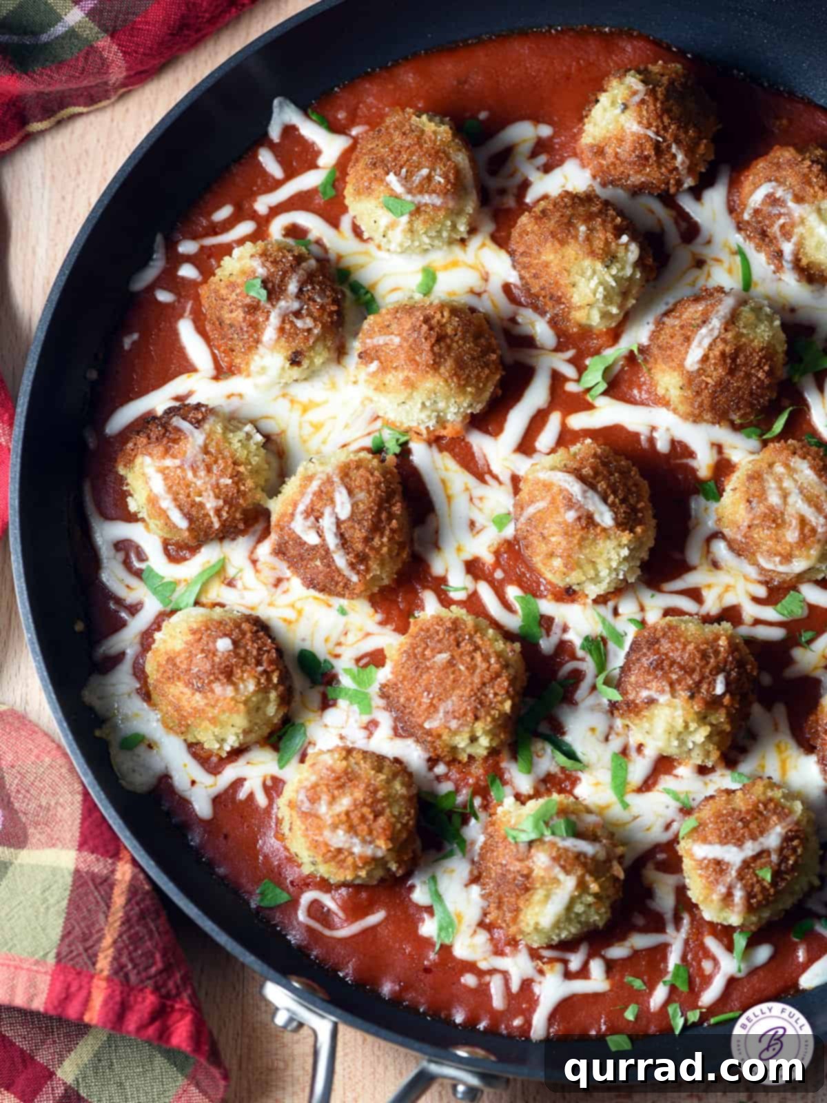 golden brown chicken meatballs in a skillet with vibrant red tomato sauce
