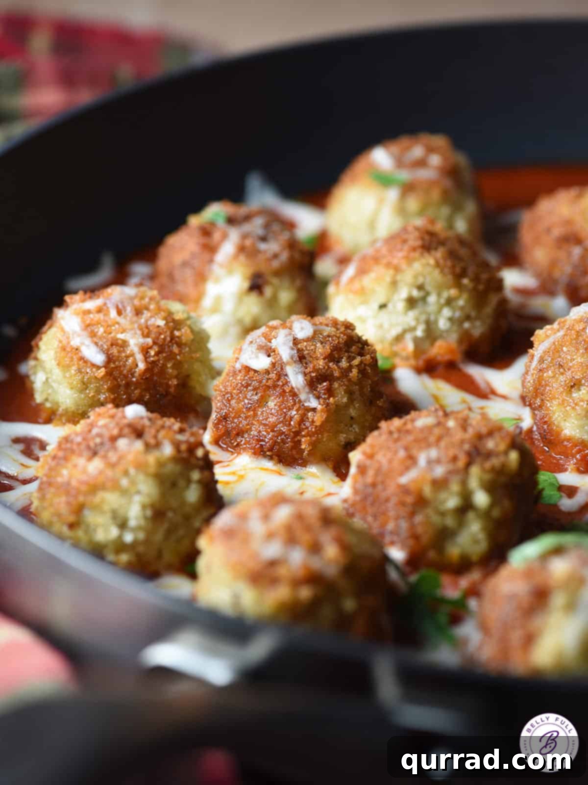 close up of breaded chicken meatballs browning in a pan
