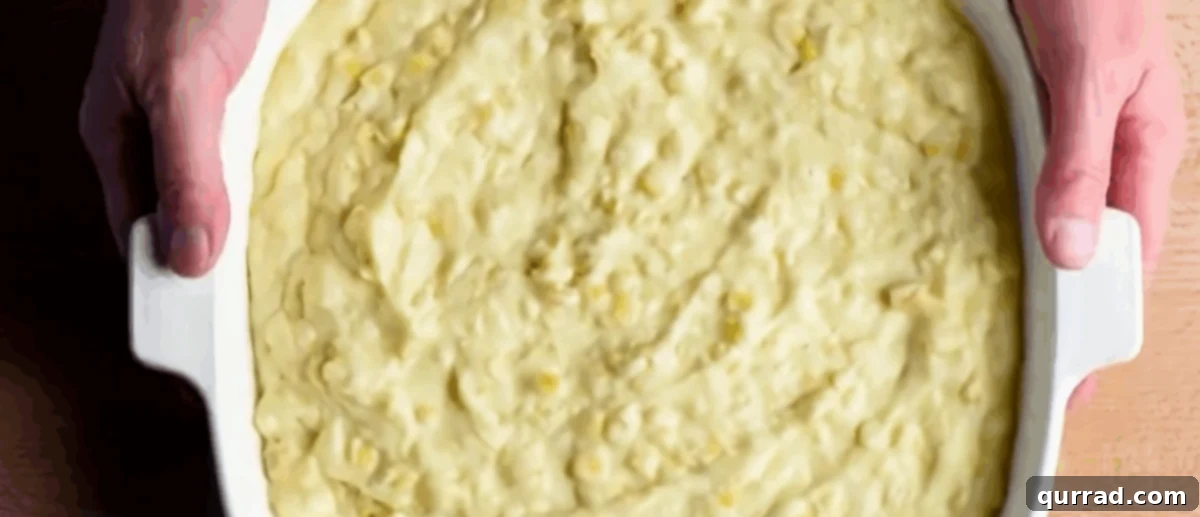 Cornbread batter in a white baking dish.