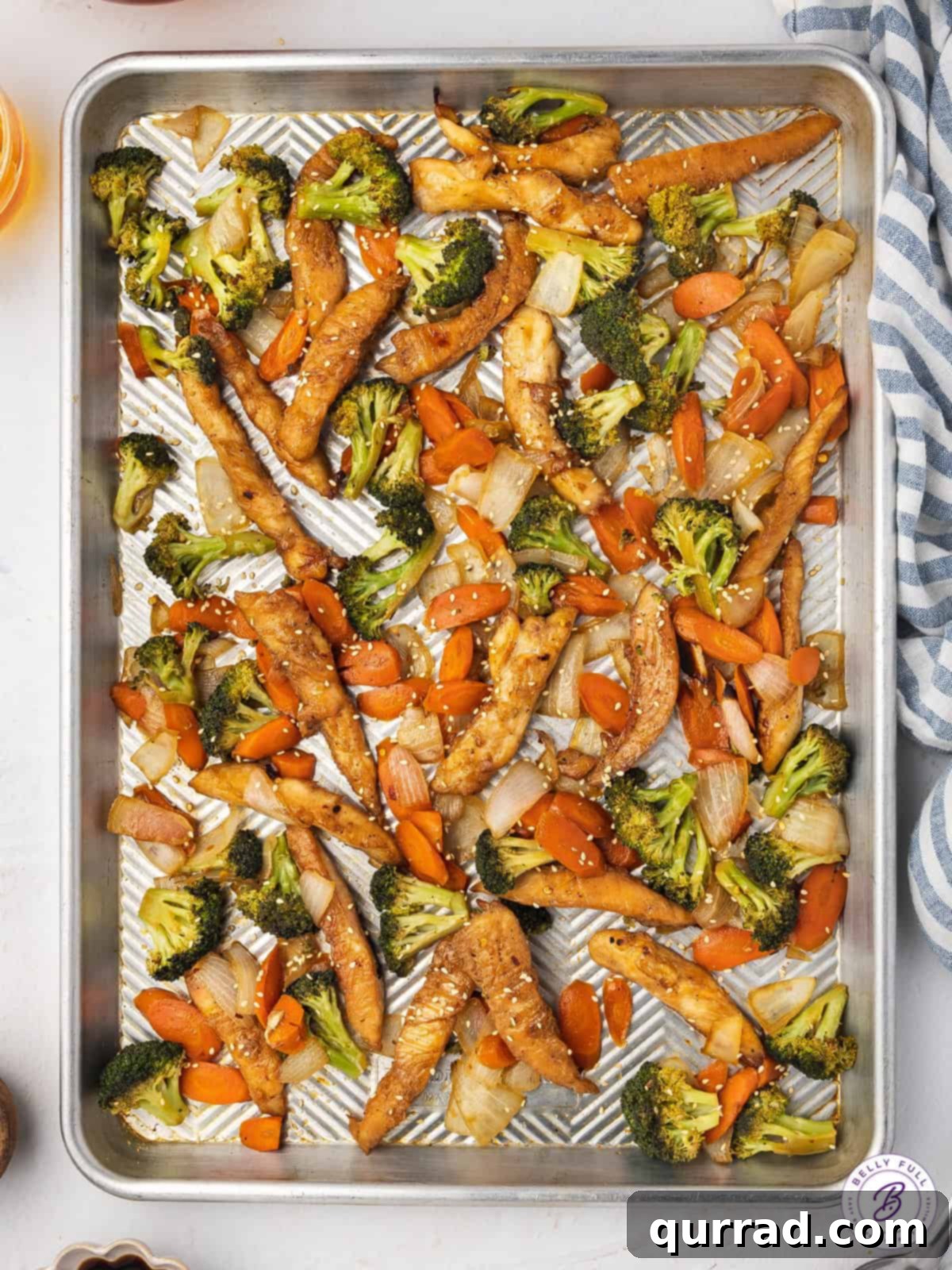 One-Pan Teriyaki Chicken and Veggies 2 A vibrant sheet pan dinner featuring golden-brown teriyaki chicken pieces and an array of colorful, roasted vegetables like broccoli, carrots, and onions, all glistening with savory sauce, ready to be served.