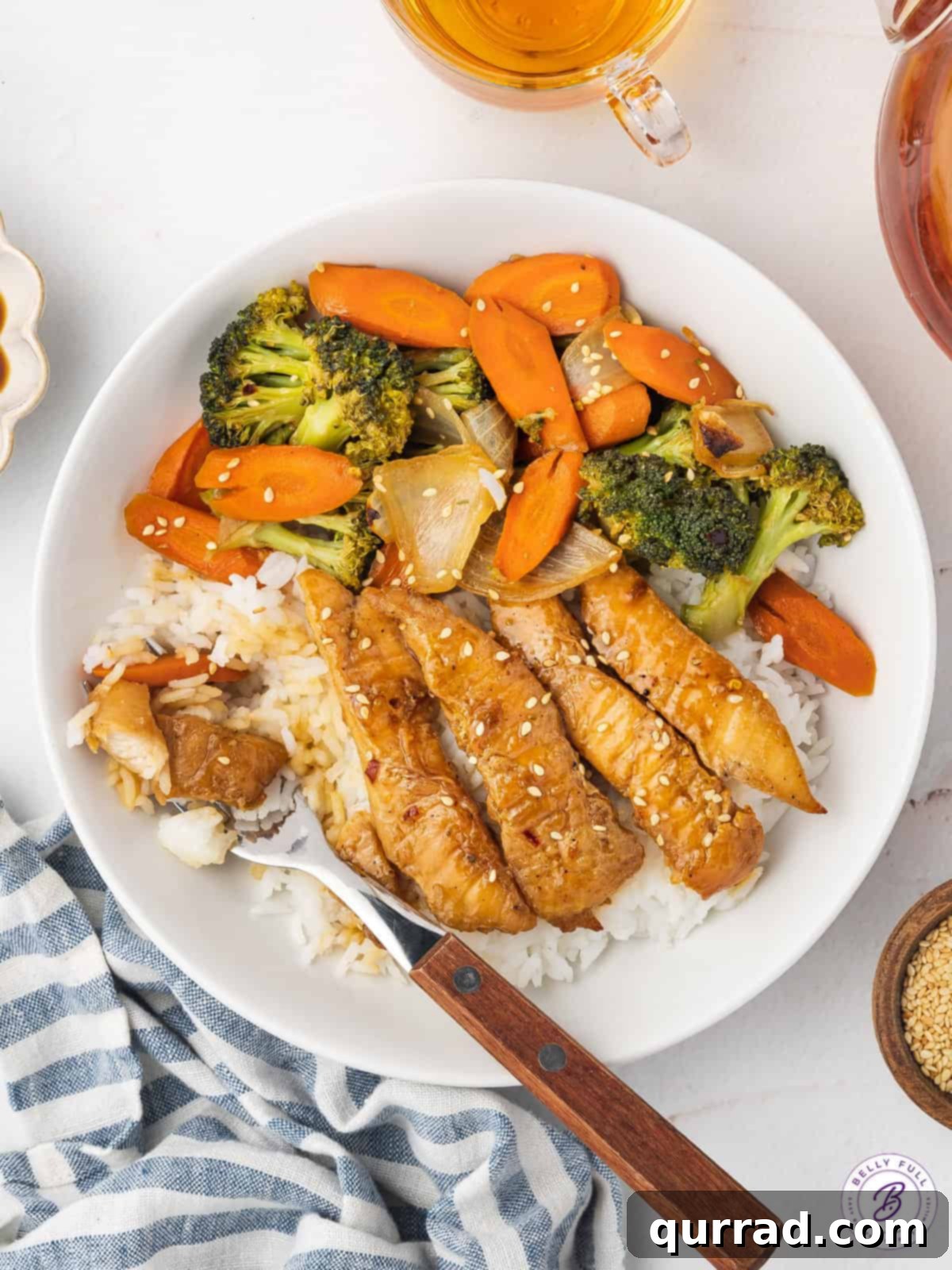 One-Pan Teriyaki Chicken and Veggies 5 An overhead view of a serving of Sheet Pan Teriyaki Chicken and Vegetables nestled on a bed of white rice in a bowl, ready to be enjoyed as a hearty and flavorful meal.