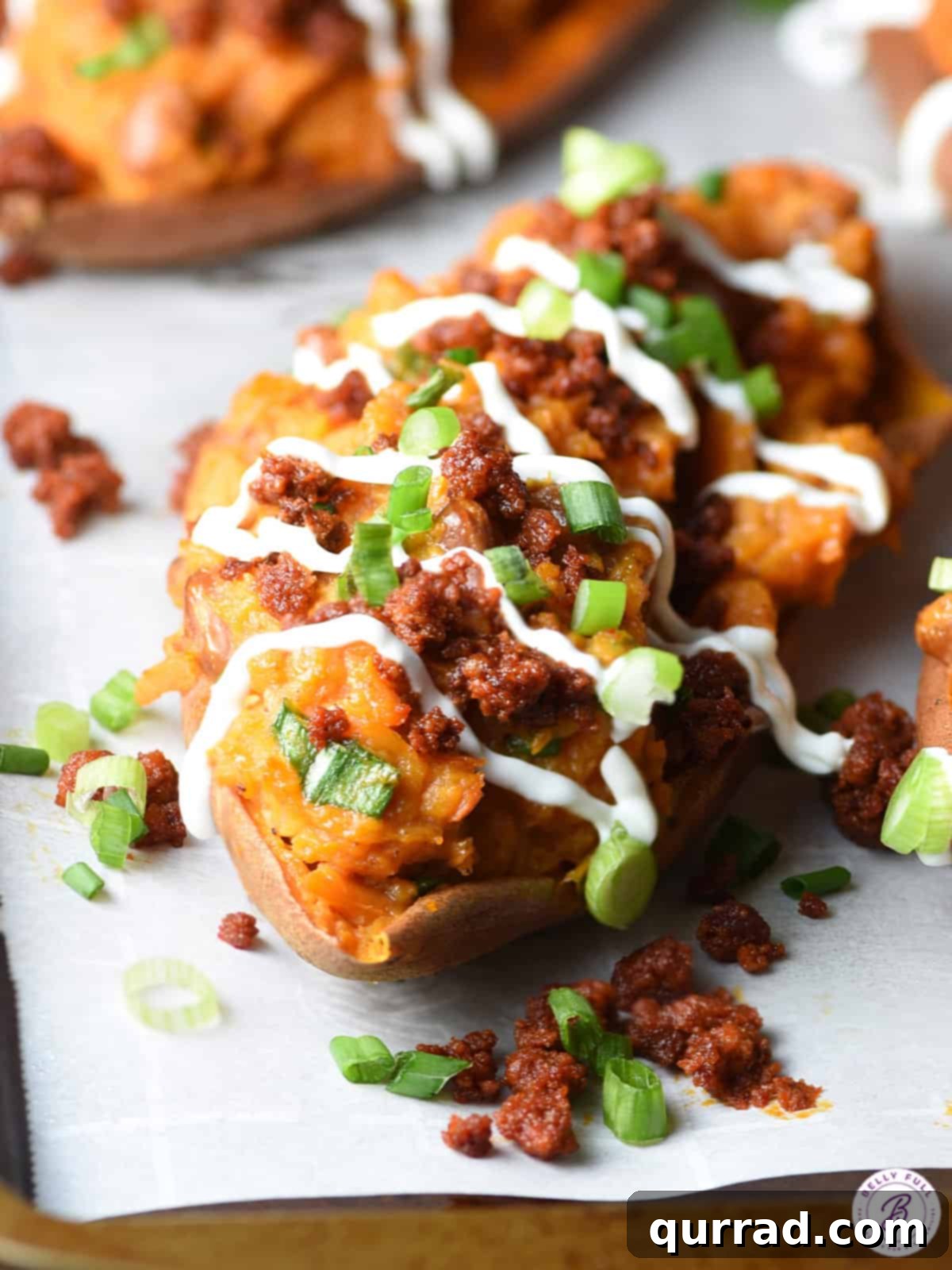 Baked sweet potato with chorizo and sour cream drizzle, showcasing a vibrant and appetizing dish