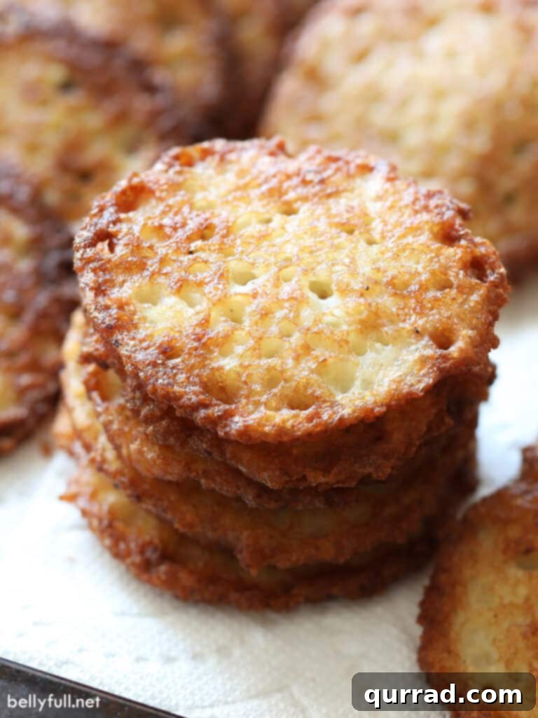 Crispy Potato Pancakes 9 A tall, artfully stacked pile of golden potato latkes, showcasing their appealing crispy texture.