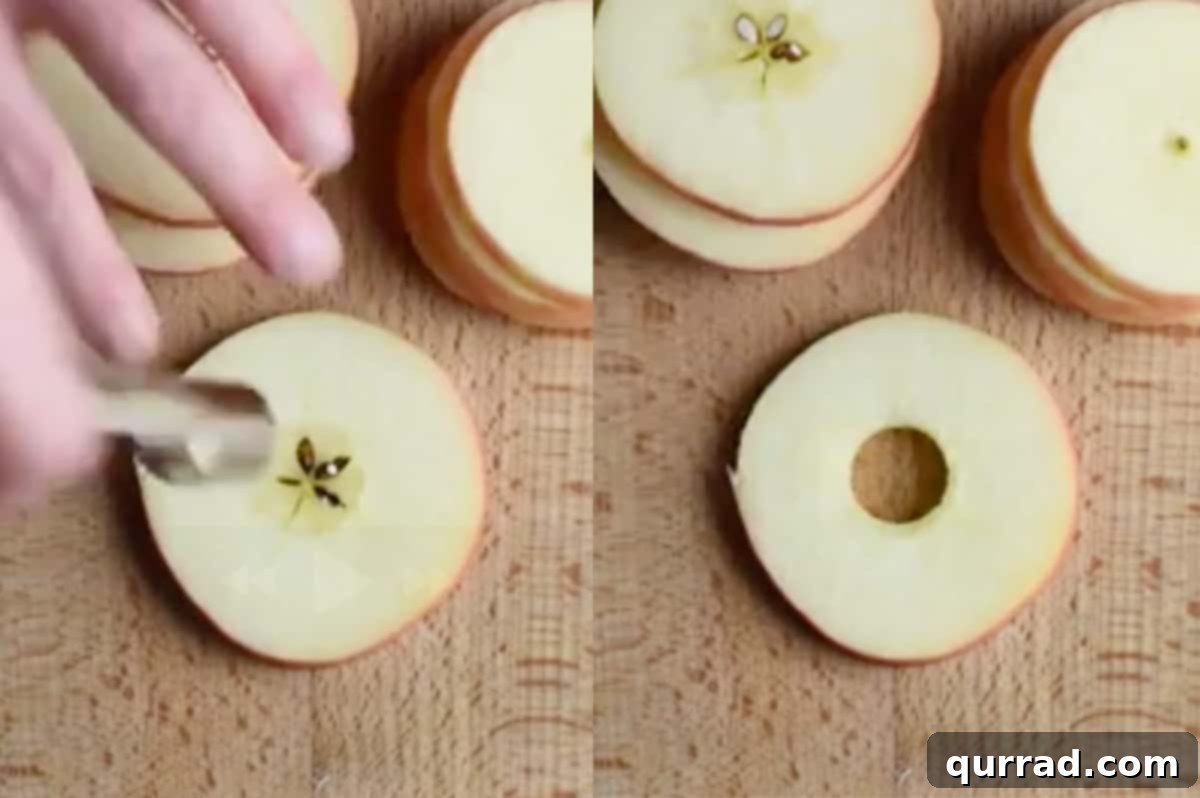An apple corer removing the core from a perfectly sliced apple round, creating a ring.