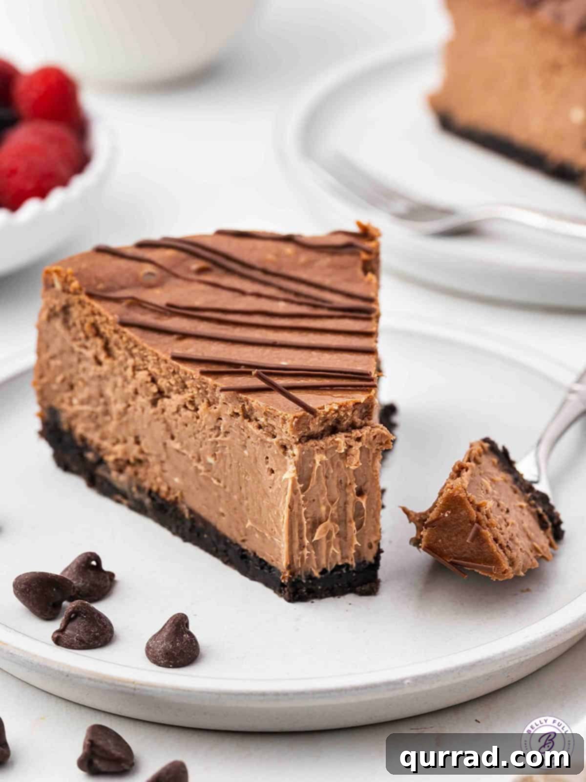 a slice of chocolate cheesecake on plate with bite on fork