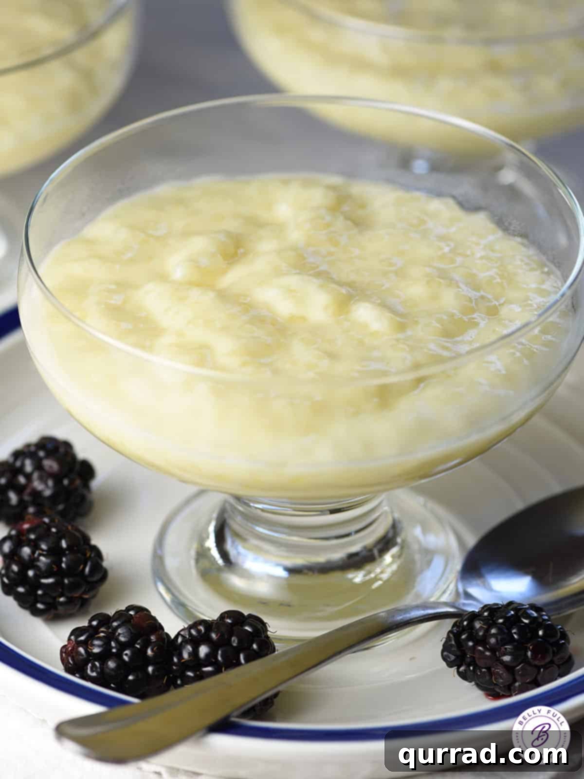 Creamy homemade tapioca pudding served in an elegant glass dessert cup, garnished with a sprinkle of cinnamon.