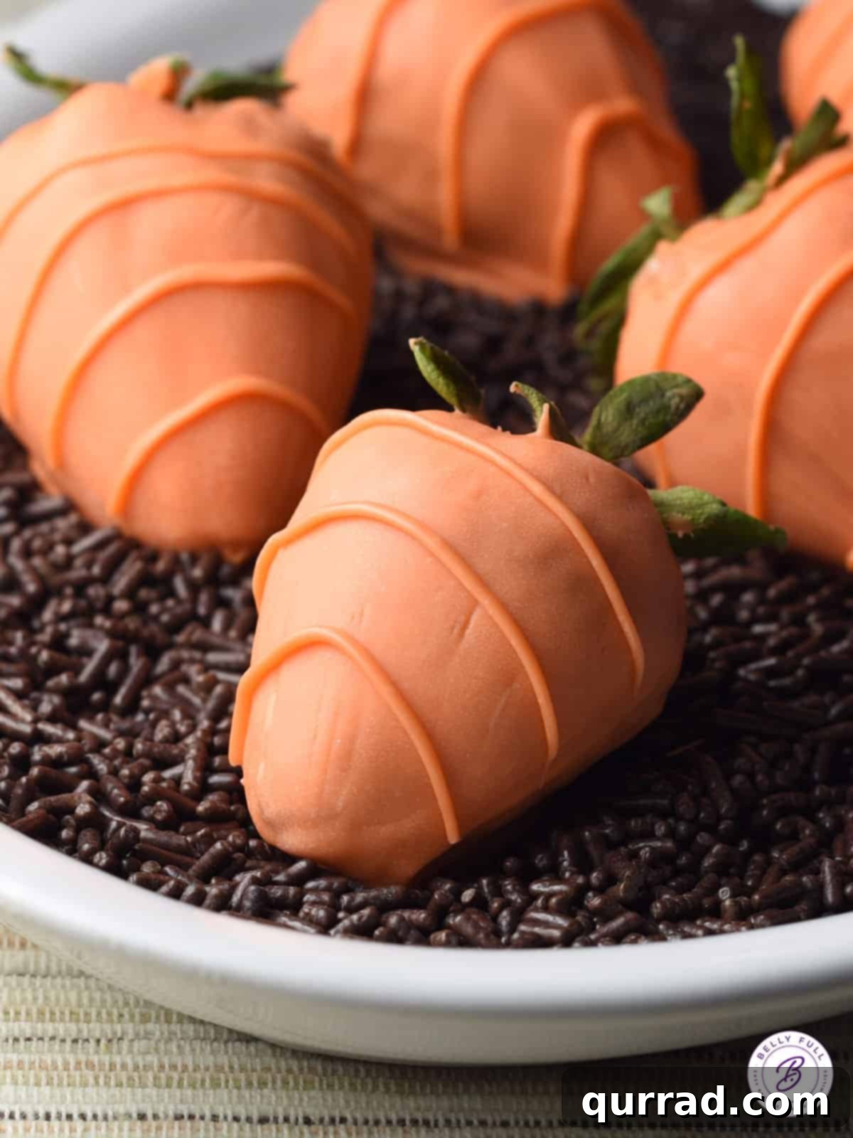 Each candy-coated strawberry is a bite-sized piece of edible art, perfect for any spring celebration, featuring a smooth orange shell and delicate stripe details. Close-up view of candy coated strawberry carrots showing intricate drizzle details