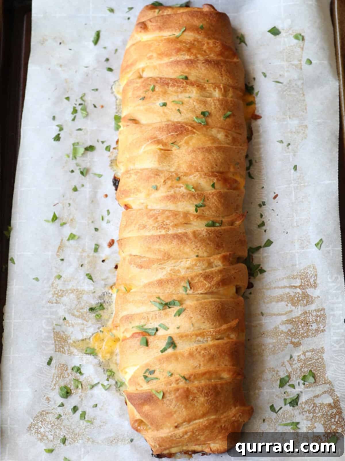 Effortless Morning Braid 3 whole breakfast braid baked on parchment paper, golden brown and ready to slice