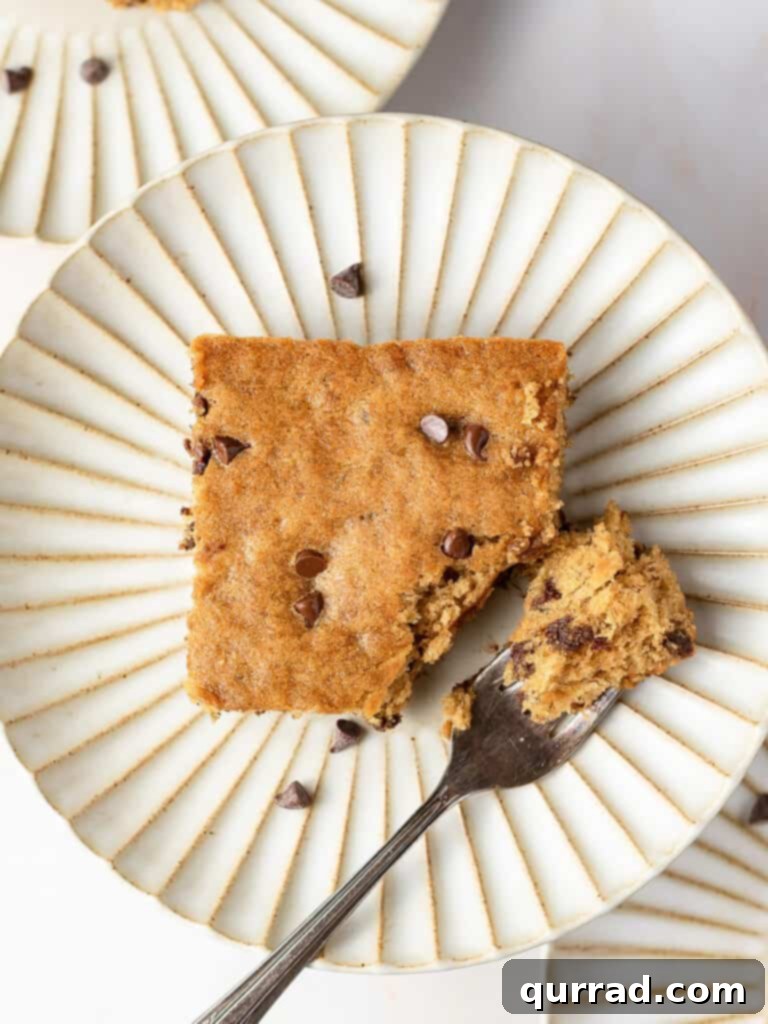 One-Pan Banana Dream 4 square piece of cake with mini chocolate chips on plate with fork