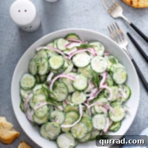 Refreshing Creamy Cucumber Medley 3 overhead picture of cucumber and onion salad in white serving dish