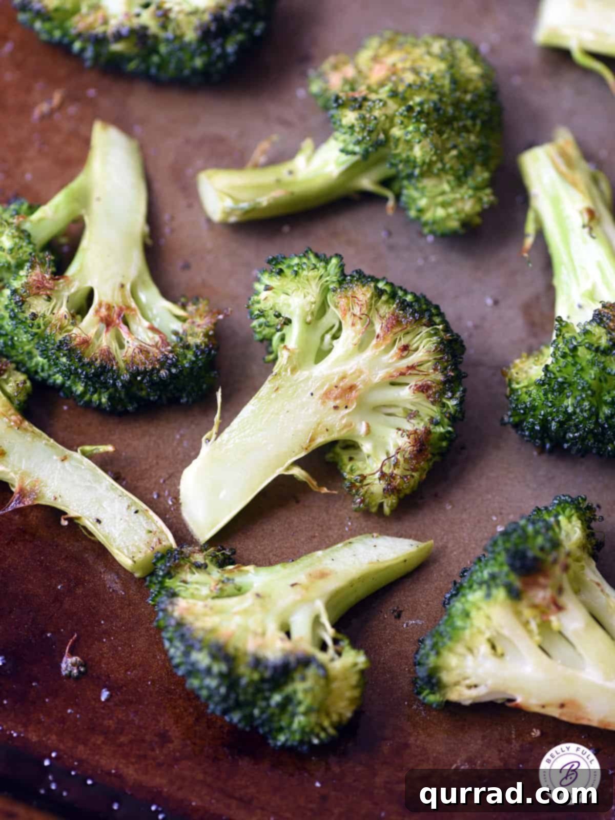 Crispy Roasted Broccoli 2 Crispy roasted broccoli florets on a baking sheet, golden brown with slight charring around the edges, ready to be served.
