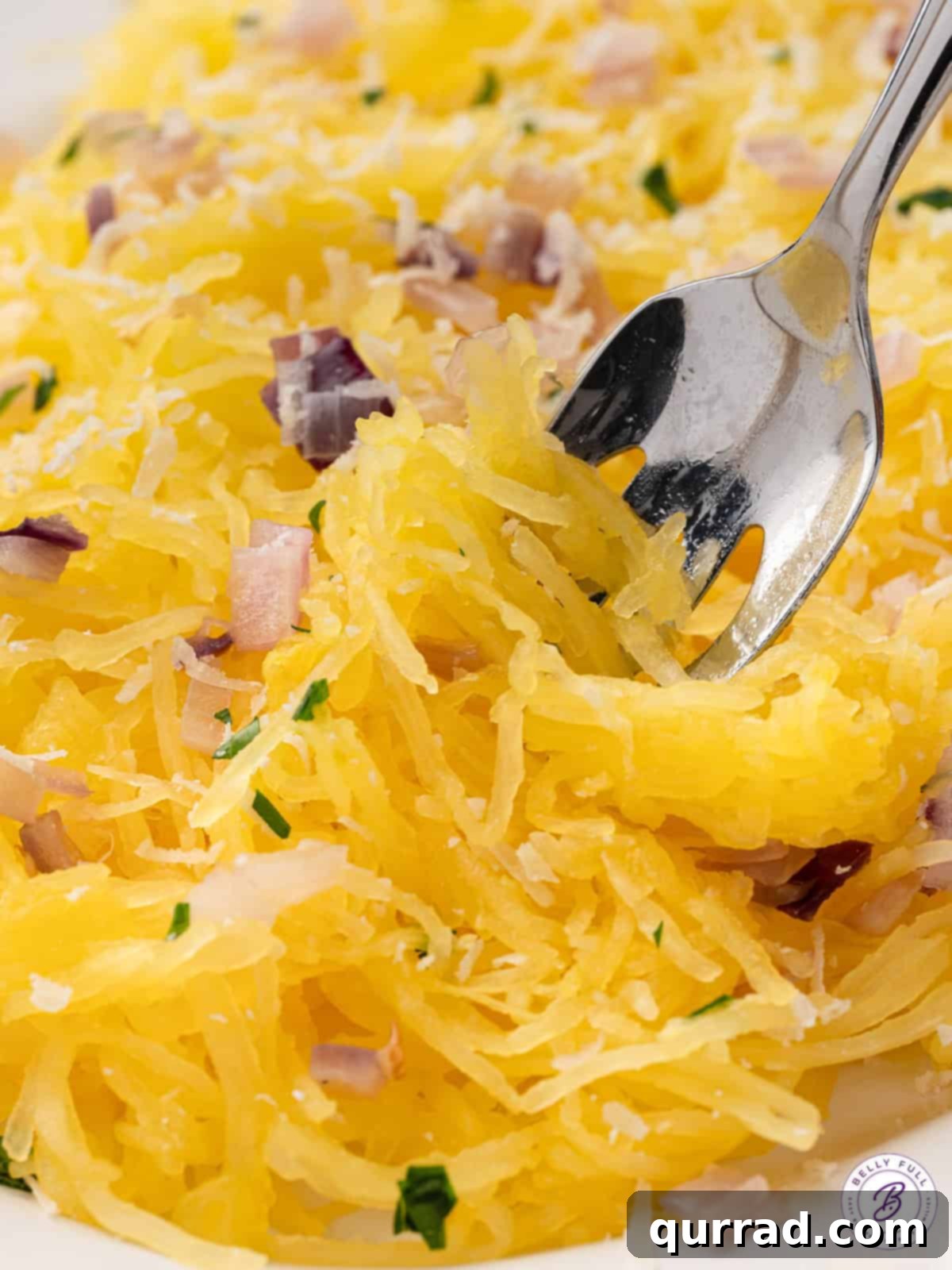 close up cooked spaghetti squash strands swirled on fork