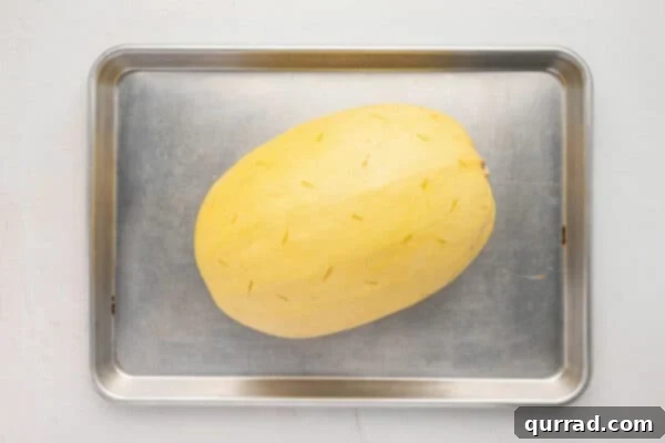 uncooked whole spaghetti squash on baking sheet