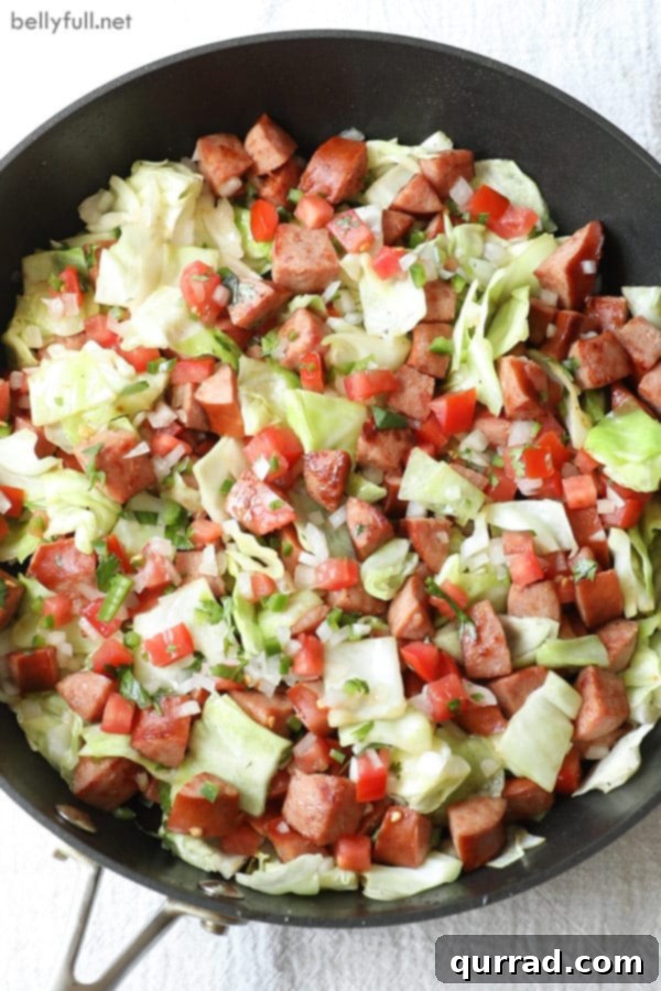 Freshly chopped cabbage, kielbasa, and pico de gallo expertly combined in a skillet, ready to be cooked into a Mexican-inspired dish. Chopped cabbage, kielbasa, and vibrant pico de gallo mixed in a pan for Mexican Skillet
