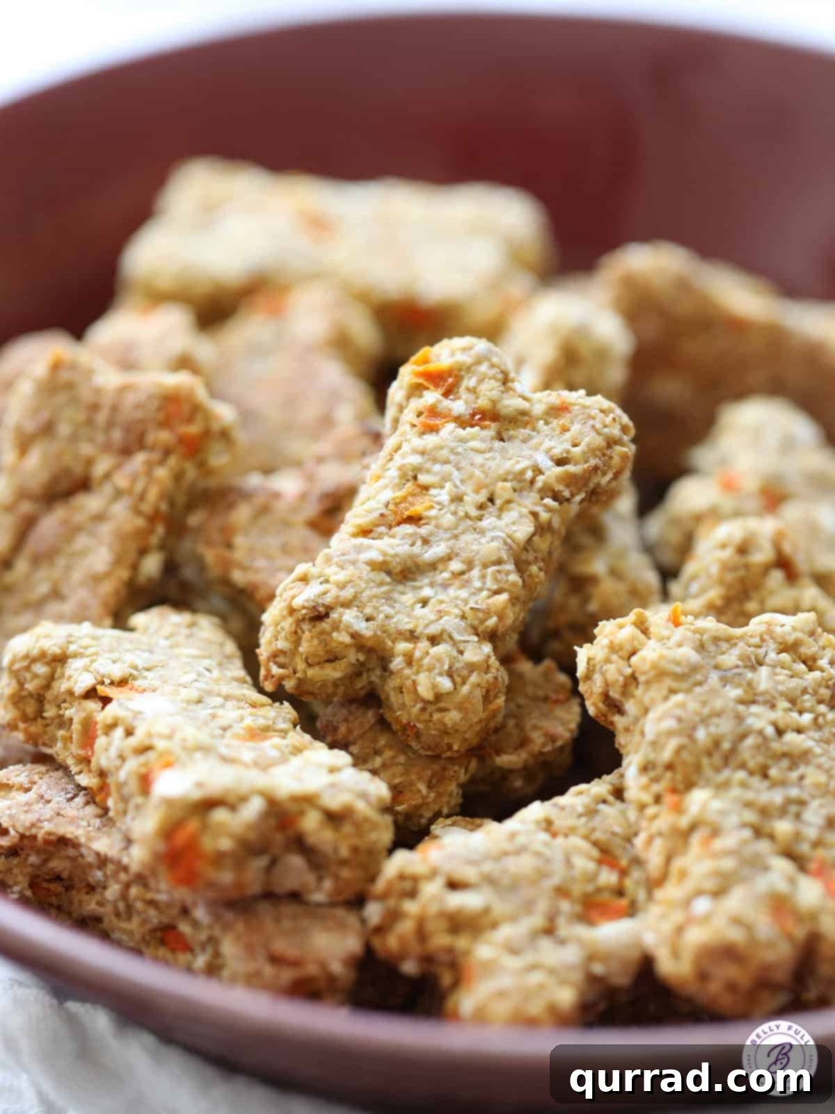 Paw-some Carrot Cake Treats 4 An appetizing display of bone-shaped homemade dog treats, perfectly baked and cooling in a bowl, ready for a happy pup.