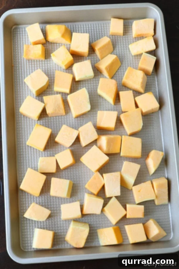 Peeled and Cubed Butternut Squash Raw butternut squash, perfectly peeled and cut into even cubes, ready for seasoning and roasting.