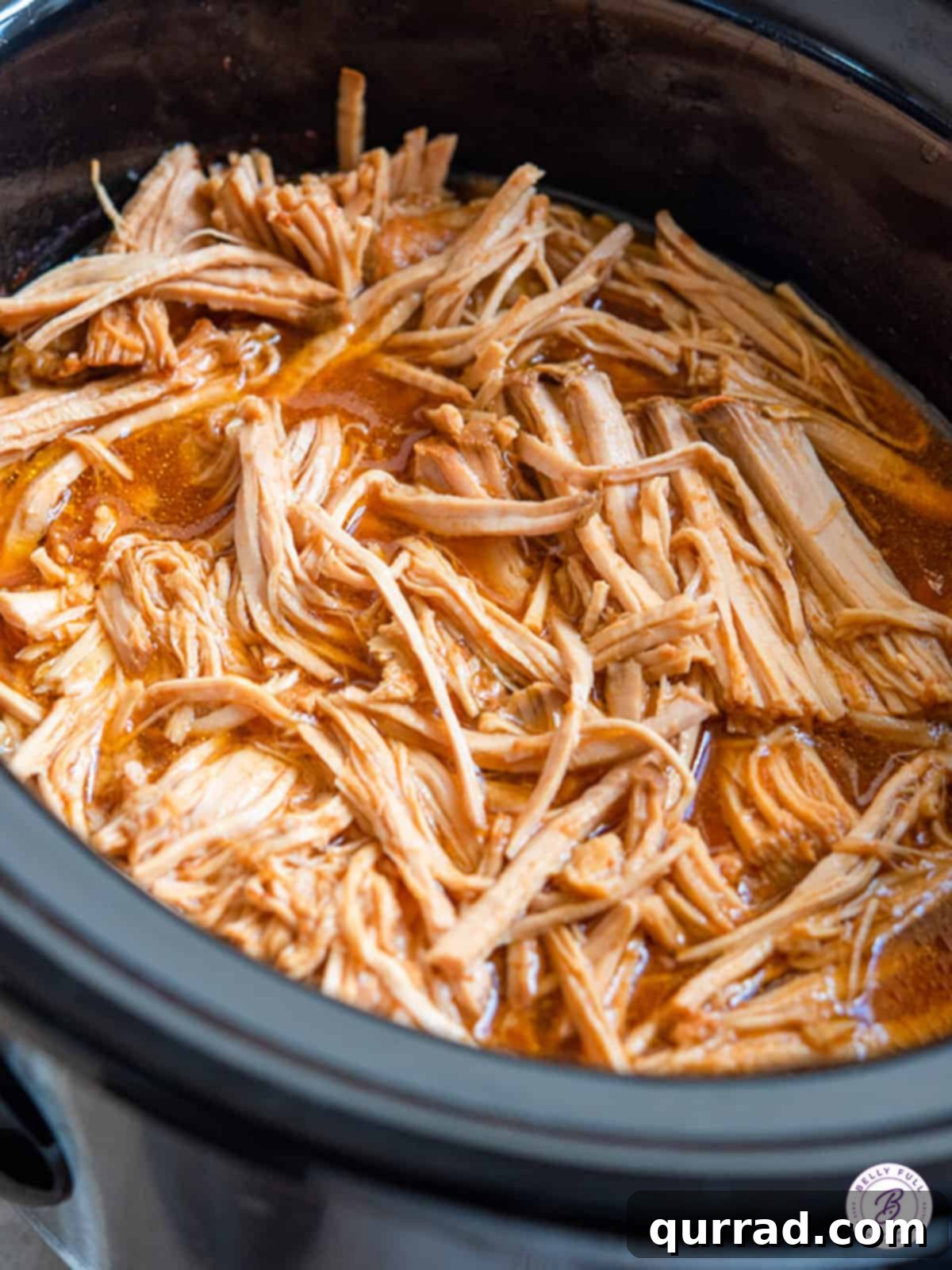 Crispy Pulled Pork Taquitos 3 Close-up of boneless pork shoulder cooking in a slow cooker with Hawaiian sauce.