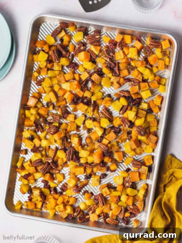 Sweet and Savory Autumn Roast with Cranberries and Pecans 2 Overhead shot of a sheet pan filled with golden-brown roasted fall vegetables, cranberries, and pecans, ready to serve.