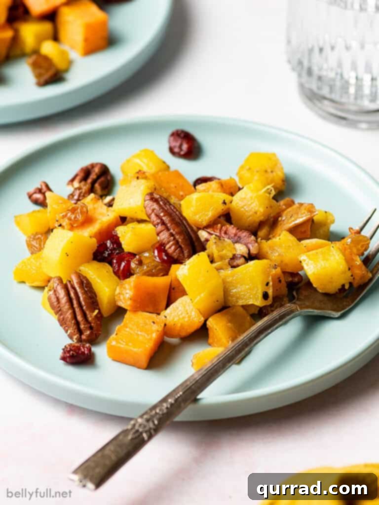 Sweet and Savory Autumn Roast with Cranberries and Pecans 5 A beautifully presented plate of roasted winter squash and pecans, emphasizing the vibrant colors and appealing texture.